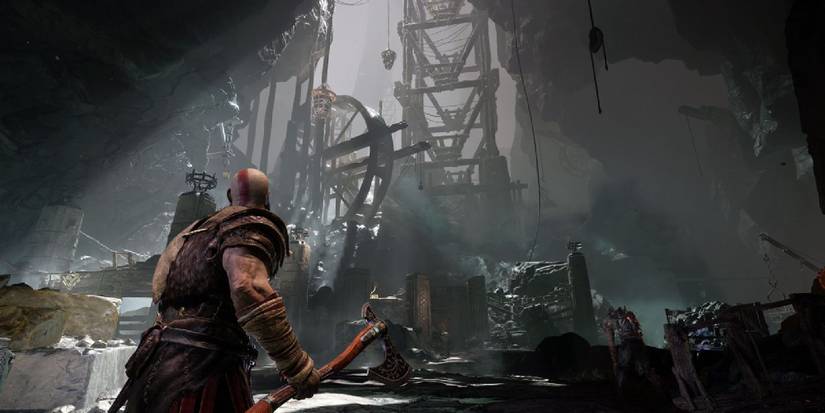 Kratos with an axe in hand, looking at the sprawling cavern before him. 