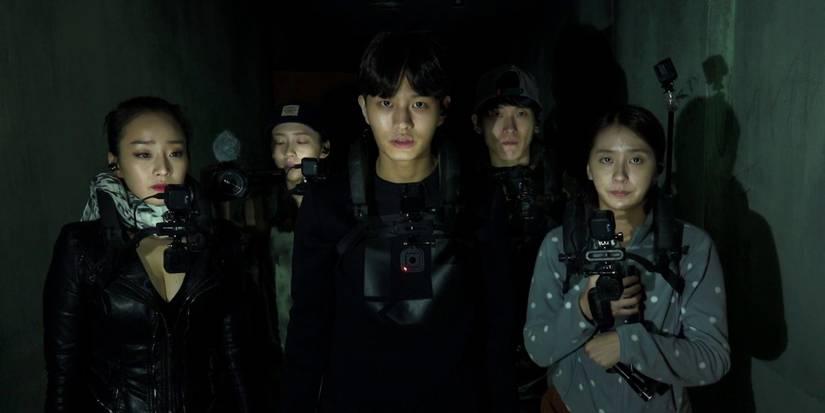 Still of five characters from the movie Gonjiam: Haunted Asylum, in a dimly lit room