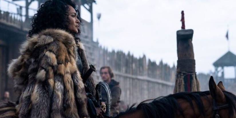 Haakon in a fur cloak riding a brown horse