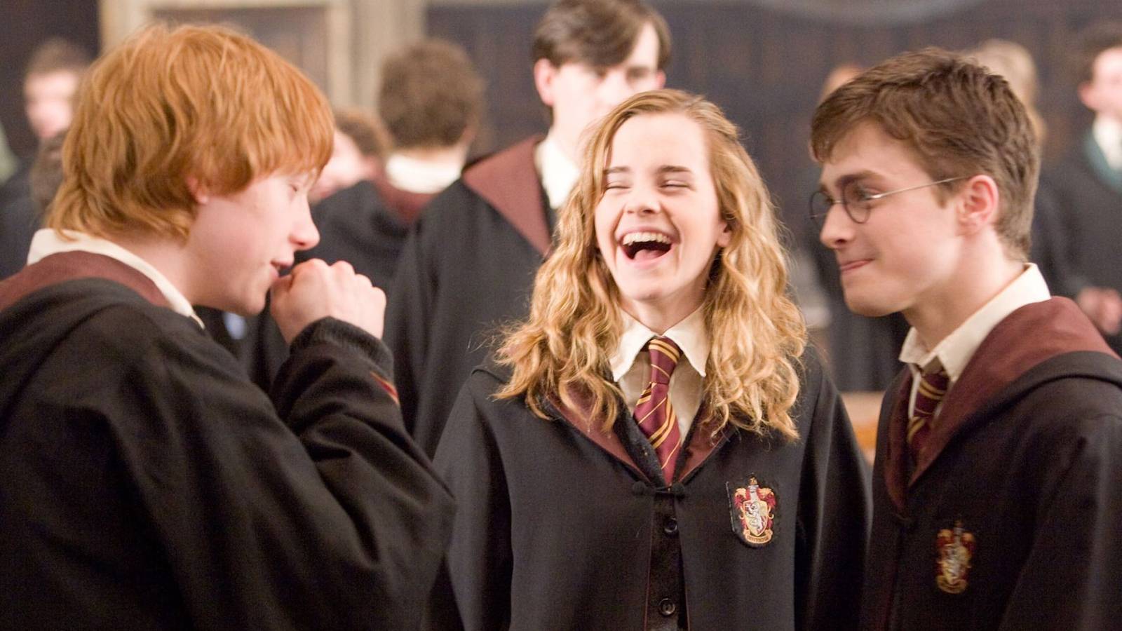 Harry Ron and Hermione laughing in Hogwarts' Great Hall in Harry Potter
