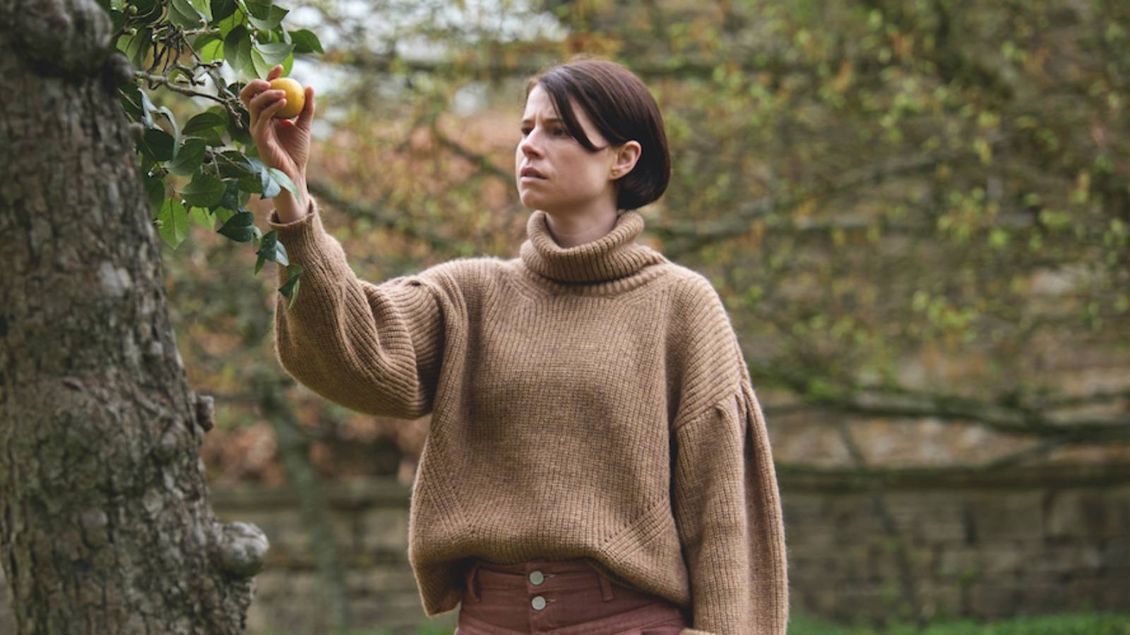 Jessie Buckley holding an apple in Men