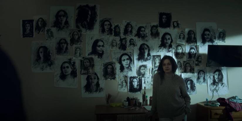 Julia Chan in Archive 81 stood with lots of drawings of a woman pinned to the wall behind her