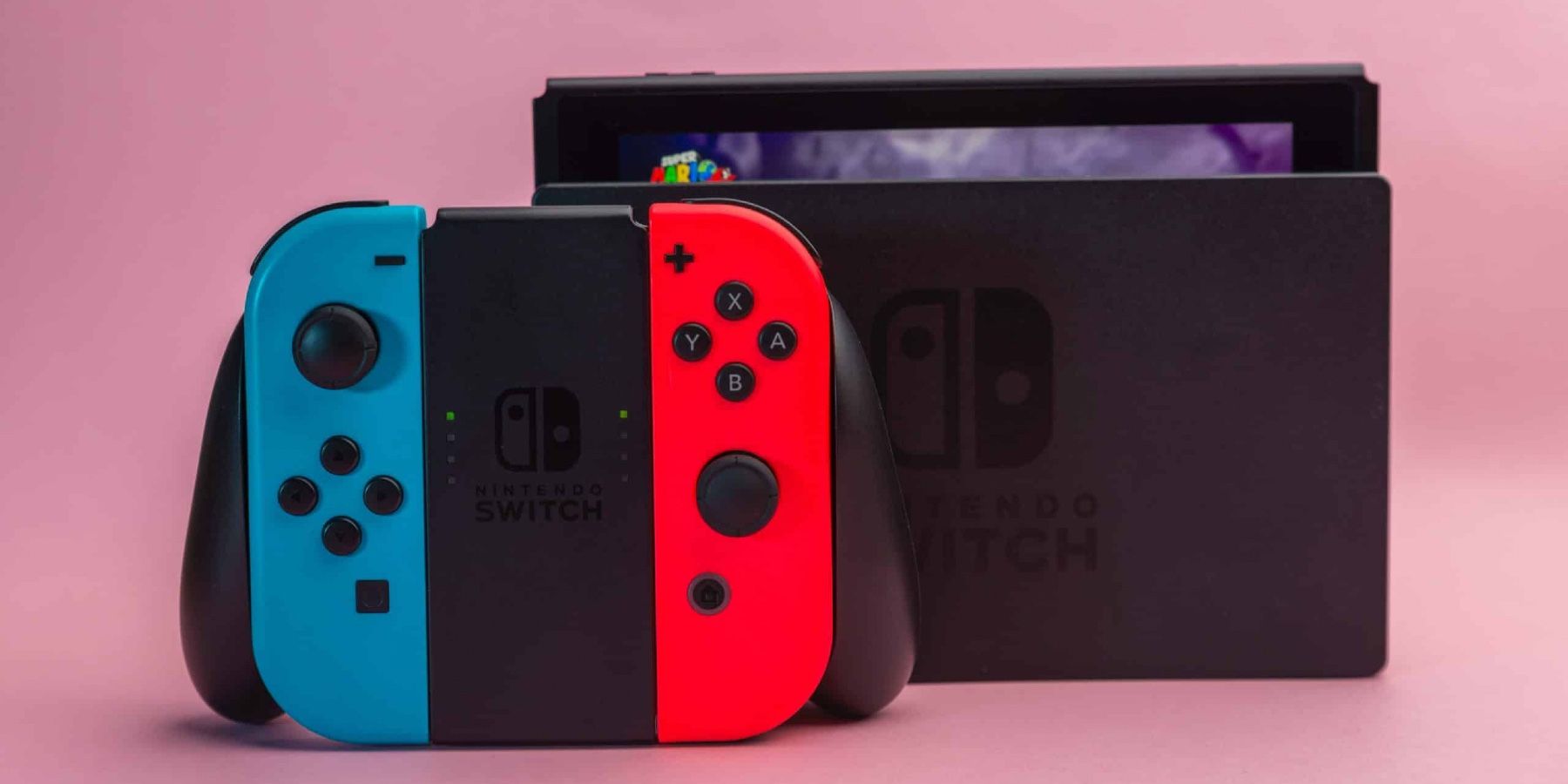 Contrôleur Nintendo Switch et dock fond rose