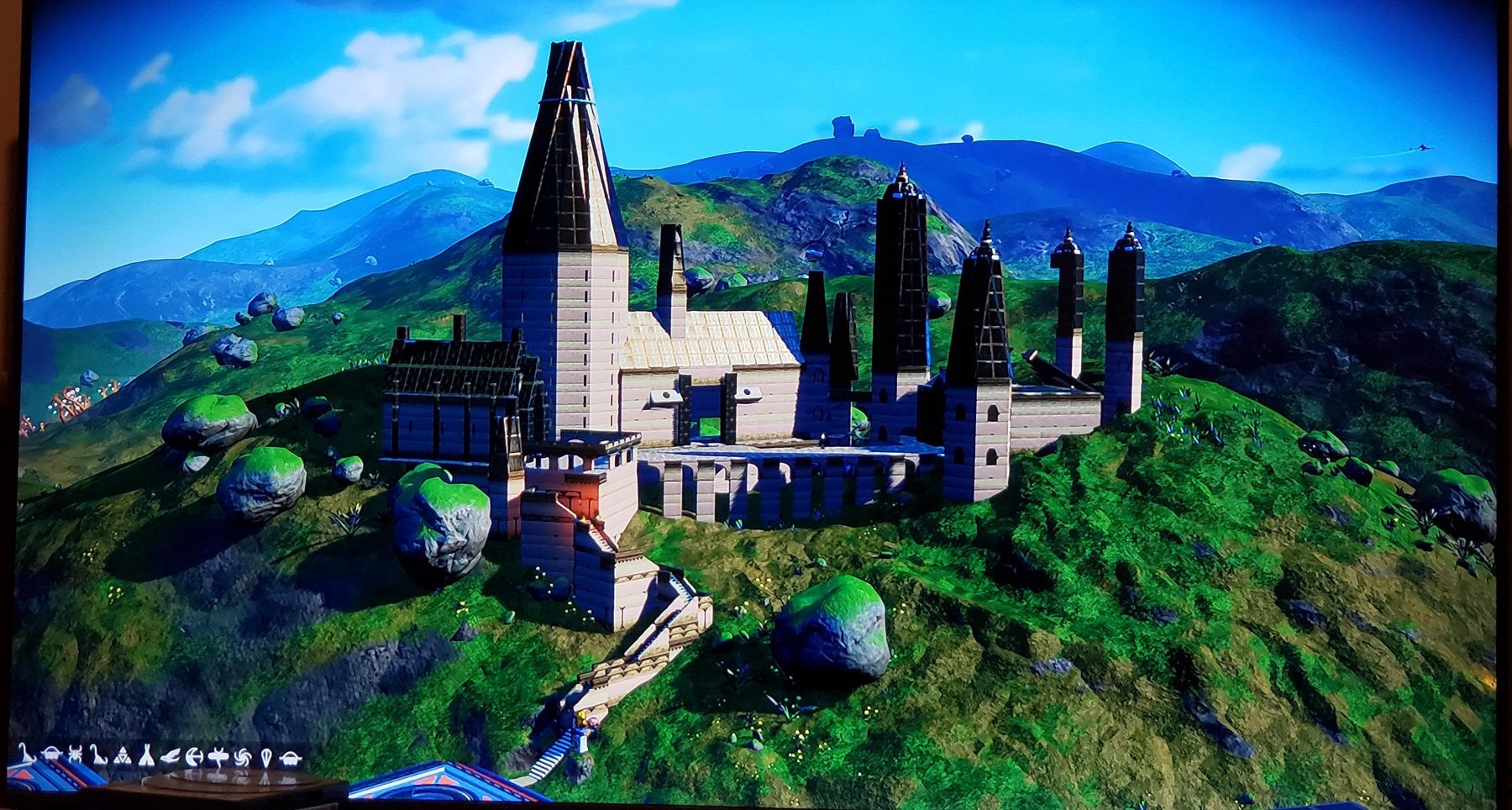 Image from No Man's Sky showing Hogwarts from Harry Potter ontop of a lush green hill.