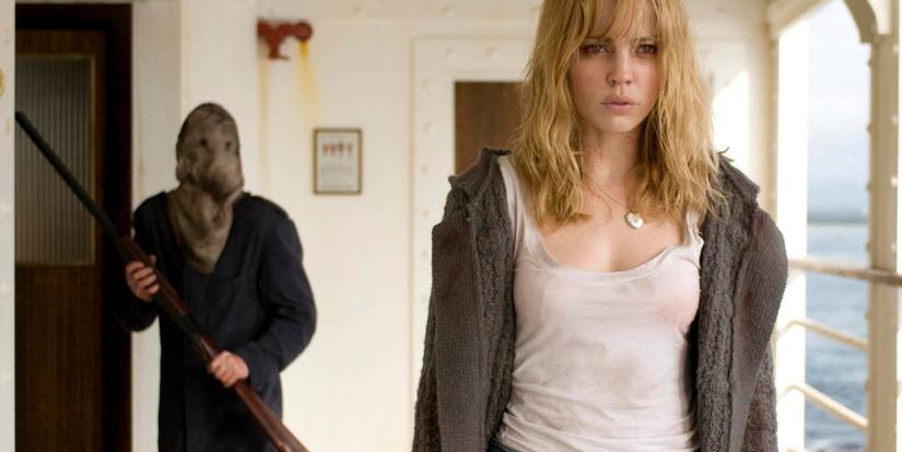 Still from the horror movie Triangle, a blonde woman on a boat being followed by a figure iwht a distorted face