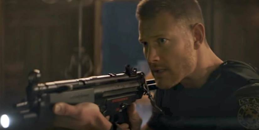 Wesker as seen in the movie, levelling a rifle at an unseen opponent.