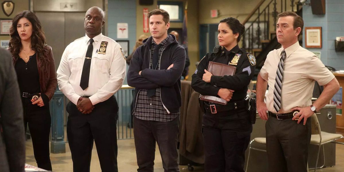 The cast of Brooklyn 99 stand together in the precinct