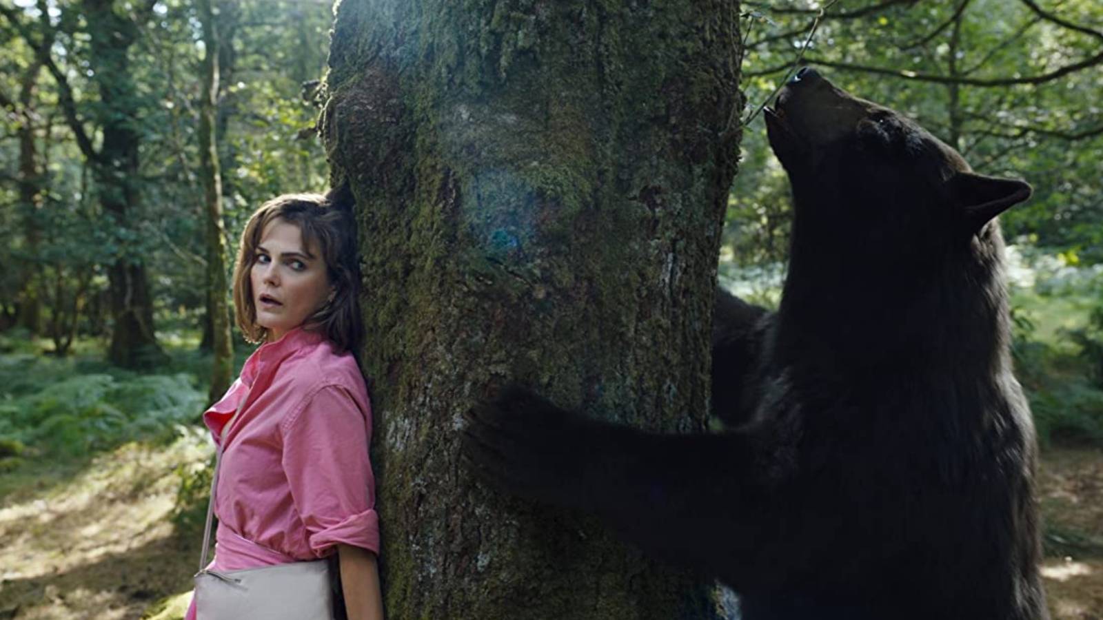 Keri Russel in Cocaine Bear hiding behind tree