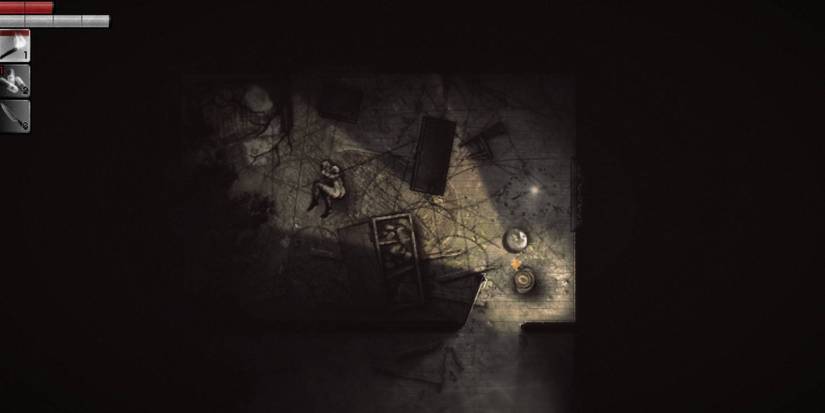 The player's in game view within a dark room that contains some overturned furniture, lit only by a handheld light