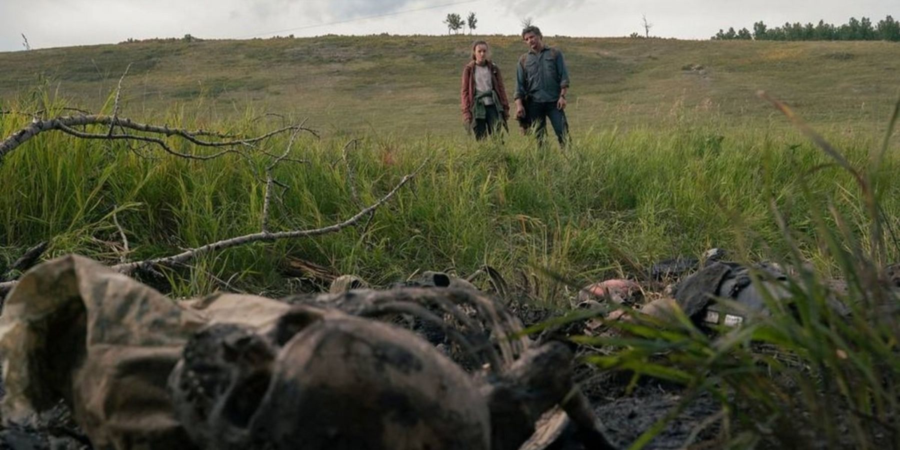 Ellie and Joel looking at skeletal remains in The Last of Us.