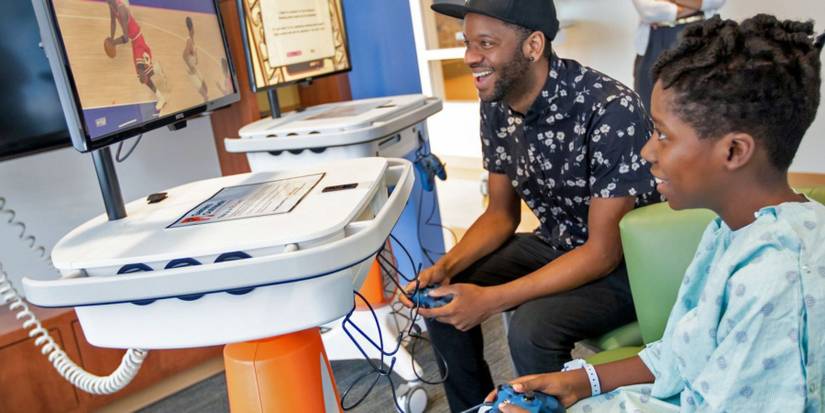 Hospital patient playing video games together with Gamers Outreach GO-Kart