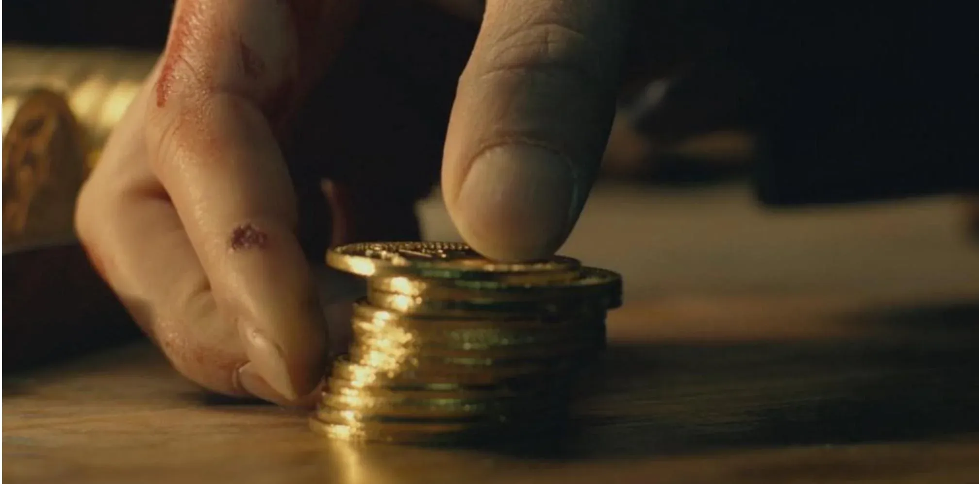 Hand holding a pile of gold coins (John Wick)