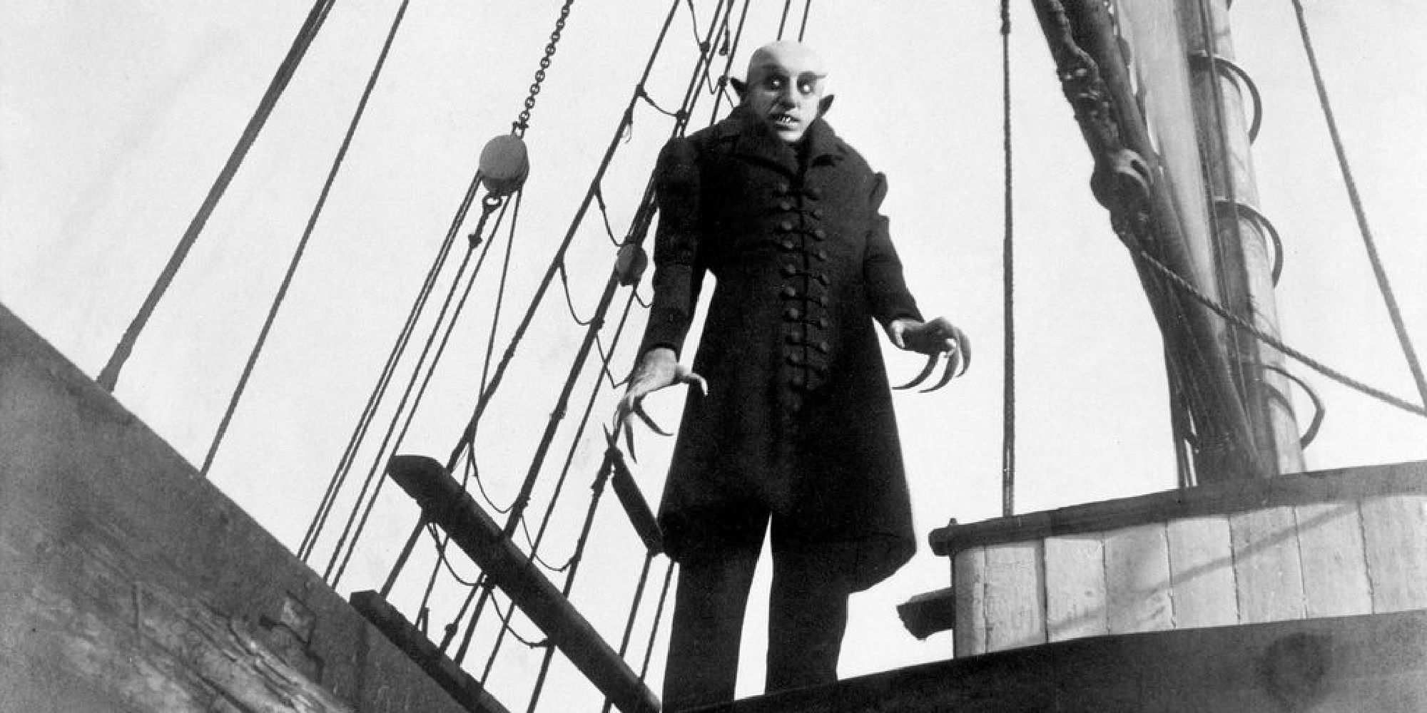 Count Orlak stands on a boat, his terrifying visage looking out over the deck. 