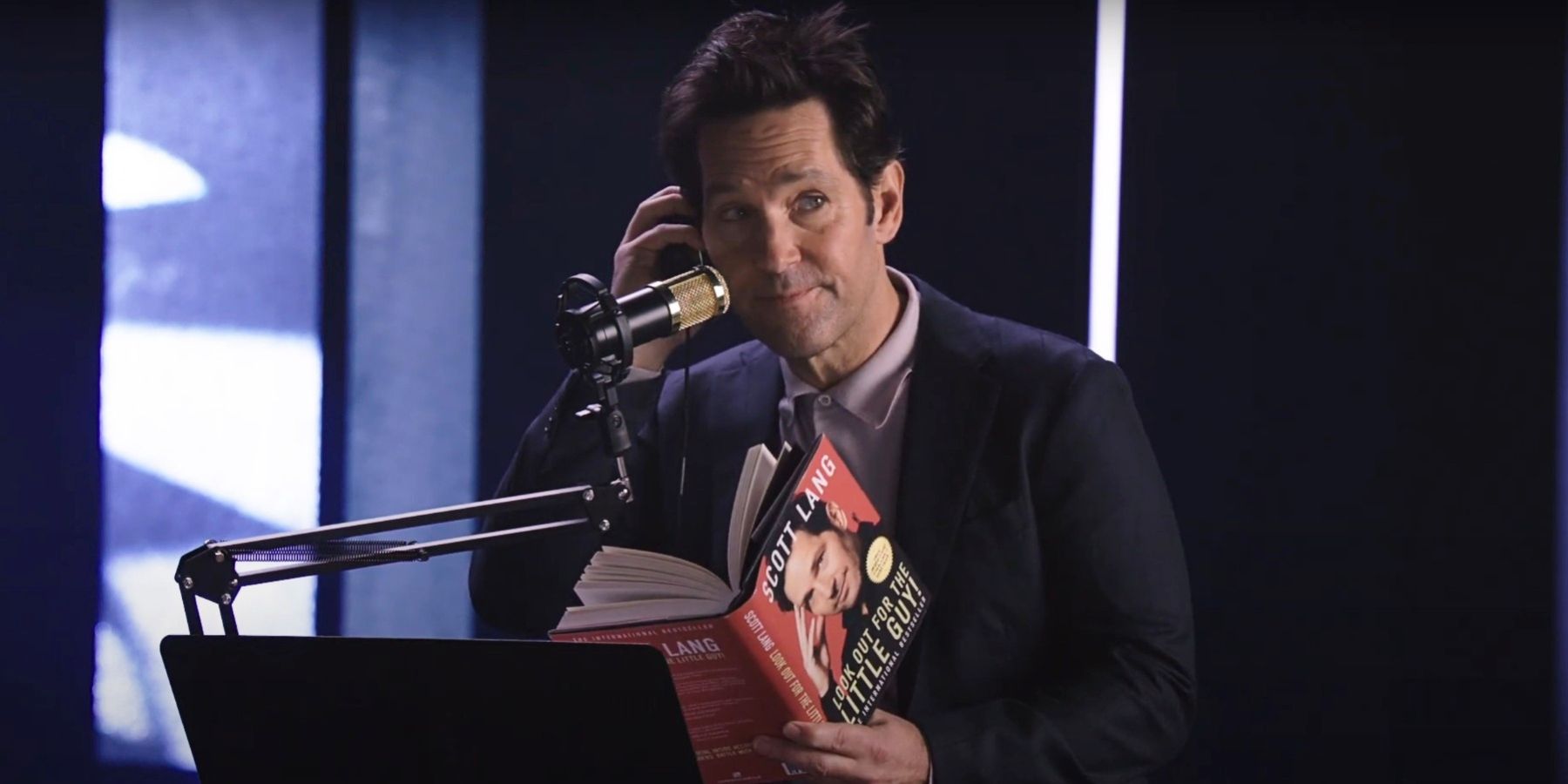 Paul Rudd reads the Ant-Man book in front of a microphone
