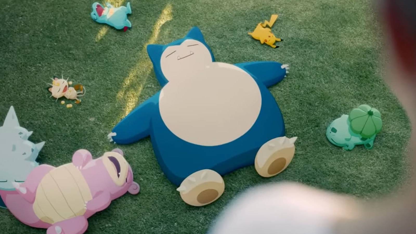 A promotional image for Pokemon Sleep, featuring Snorlax and other Pokemon sleeping in a grassy yard.