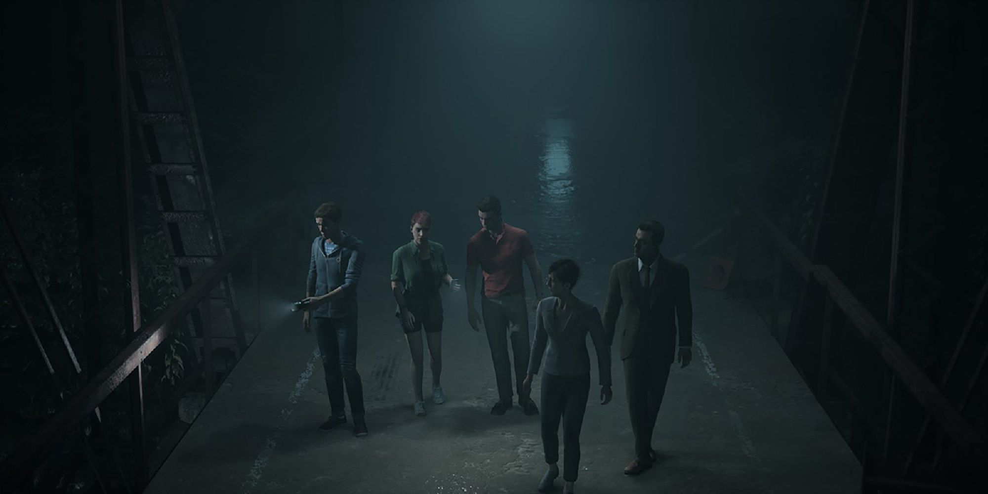 A group of people walk across a dark bridge.