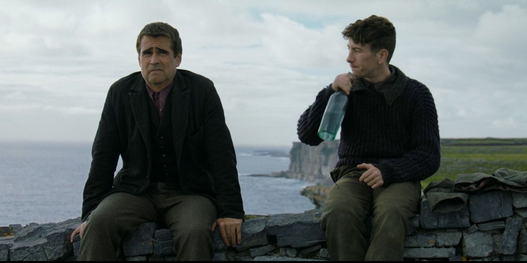 Colin Farrell as Pádraic and Barry Keoghan as Dominic sitting together in The Banshees of Inisherin