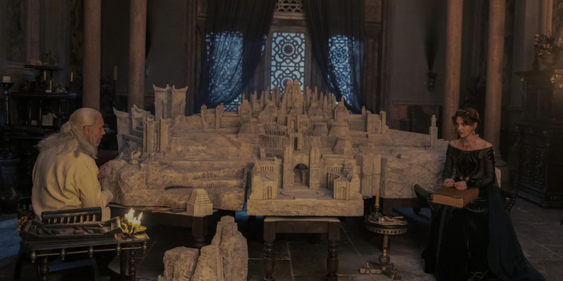 Viserys I Targaryen and Alicent Hightower in front of the model city of Old Valyria in House of the Dragon.