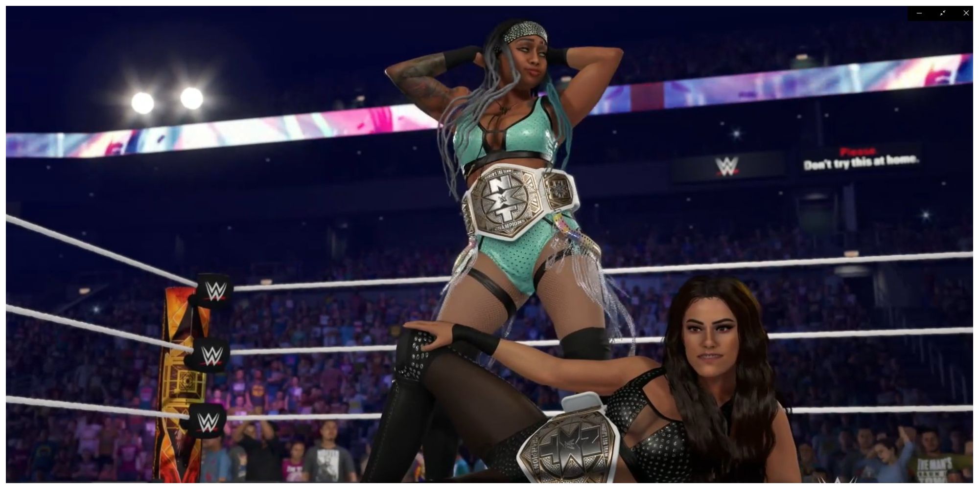 Katana Chance đứng đằng sau Kayden Carter lắc hông.  Carter đang nằm xuống, cả hai người phụ nữ đều tham gia võ đài WWE với Giải vô địch nữ NXT