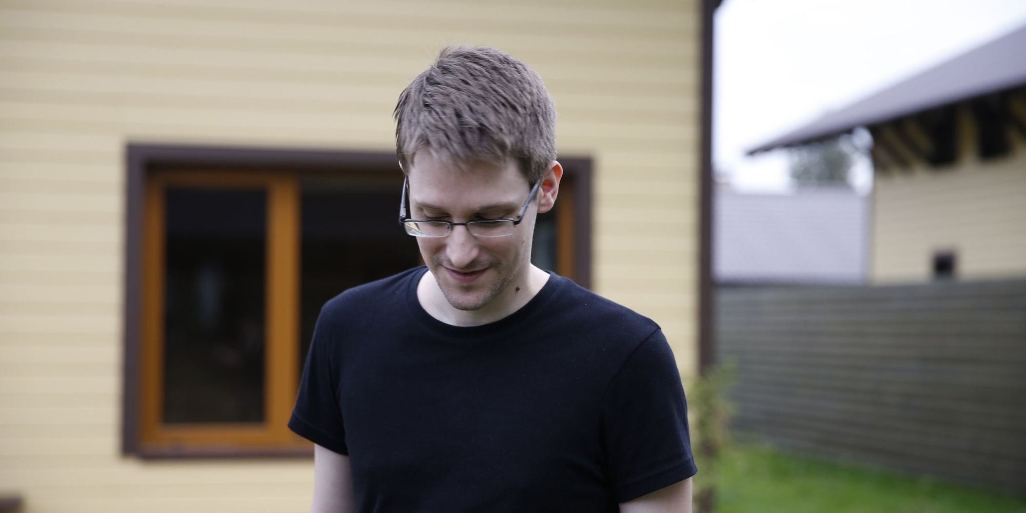 (photo) image of a white man with glasses standing in a back garden
