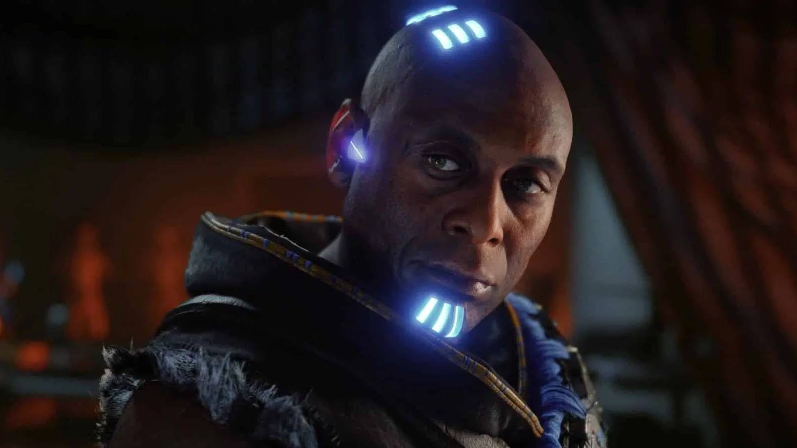 A screenshot of Horizon Forbidden West featuring Lance Reddick's Sylens in a dark room.