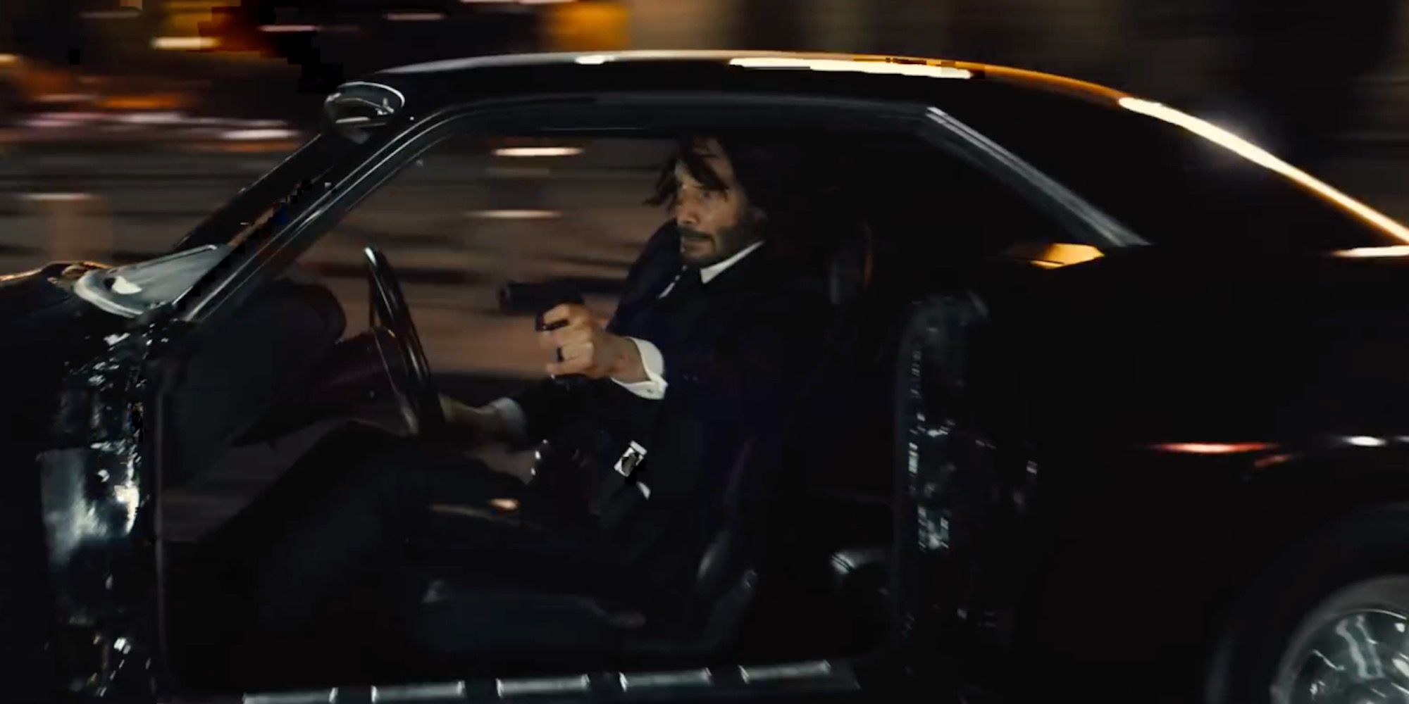 John shooting in a car in John Wick Chapter 4