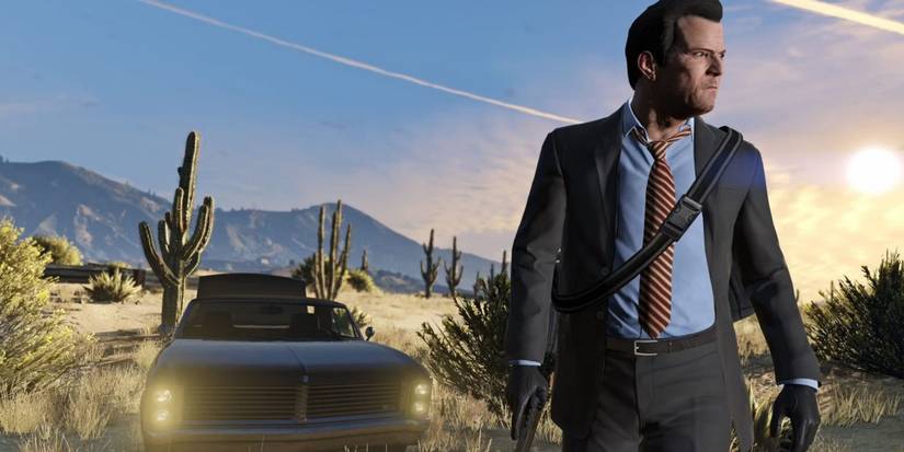 Michael De Santa standing in front of car in suit 