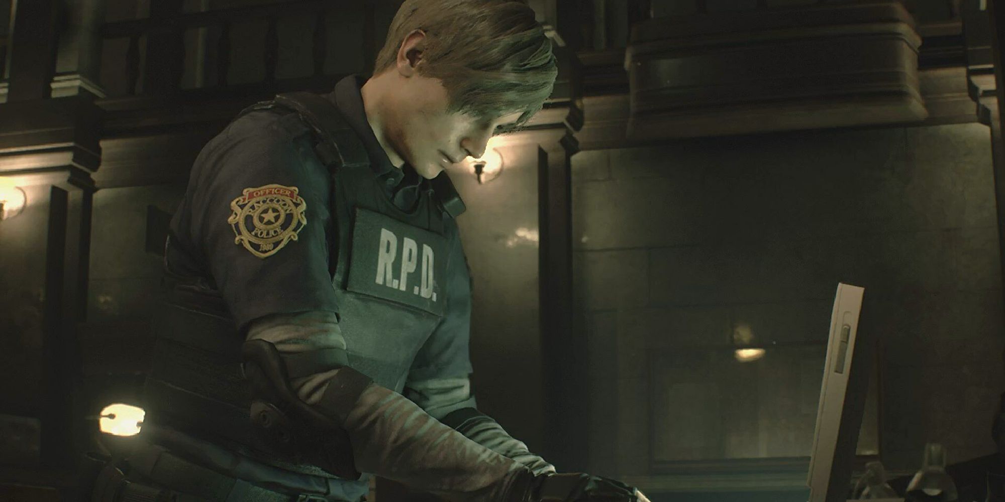 Leon as seen in the Resident Evil 2 Remake, typing at a computer terminal.