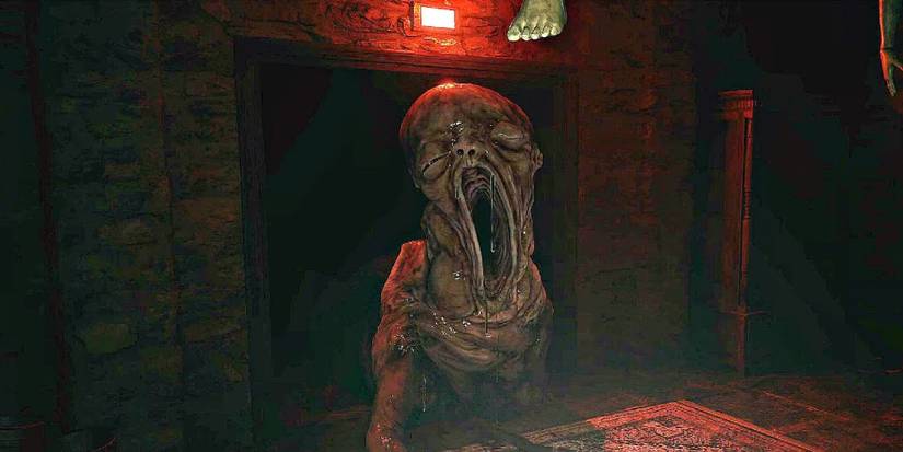 The horrifying baby monster from Resident Evil 8, crawling through a red-lit room towards the player.