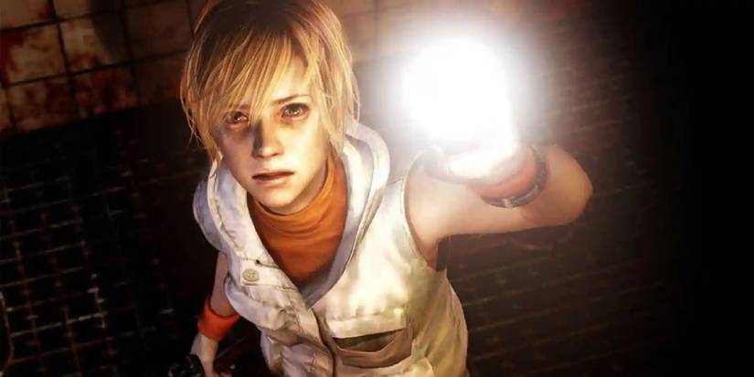 Protagonist Heather shining a flashlight at the camera with a look of concern. 