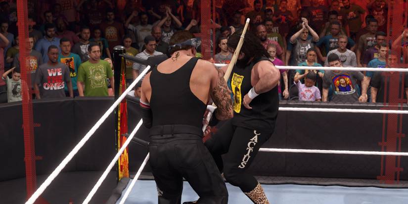 WWE2K23 Undertaker attacking Cactus with a Kendo stick