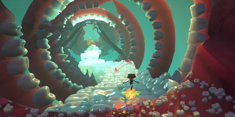 Raz using a bubble to roll over a row of teeth in Psychonauts 2