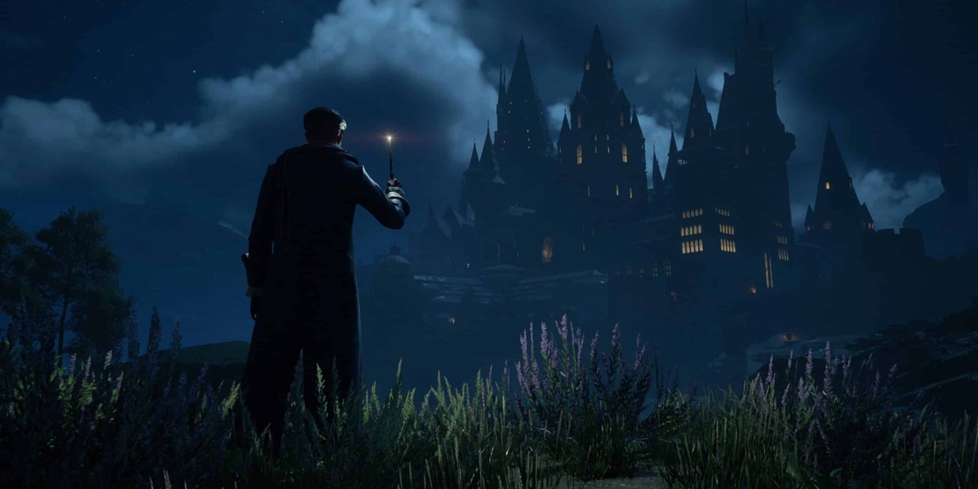 A screenshot of the main character and Hogwarts castle during the night in Hogwarts Legacy 