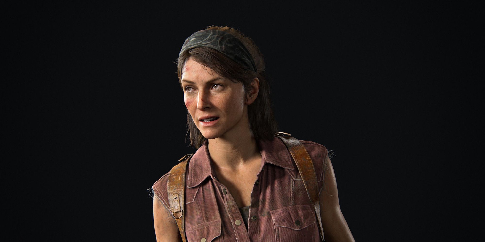 Tess, a character from The Last Of Us, looks off to the left with a steely gaze.