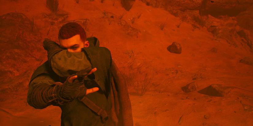 Cal walking against a sandstorm on Jedha