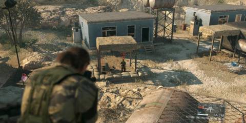 Snake looking down the sights of a gun at a guard who appears to be guarding an enemy force's base in METAL GEAR SOLID V: THE PHANTOM PAIN 