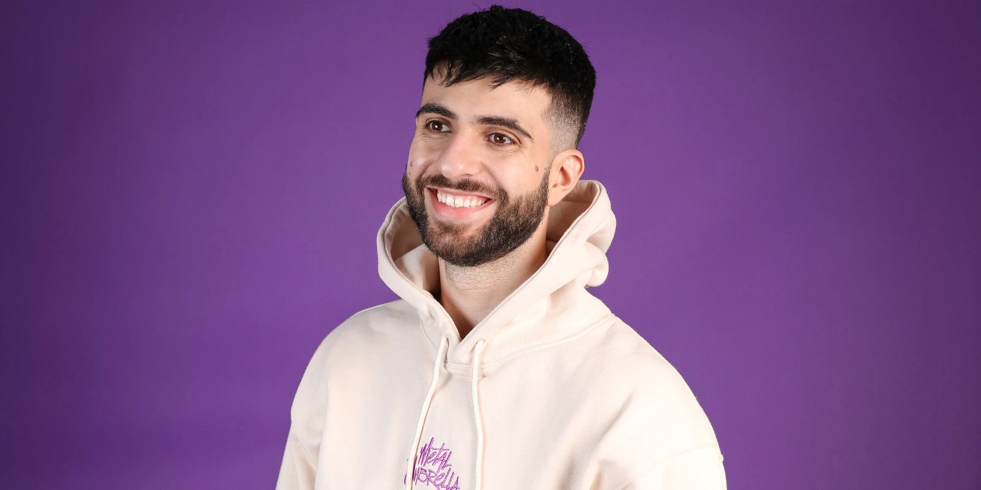 sypherpk smiling in front of a purple wall