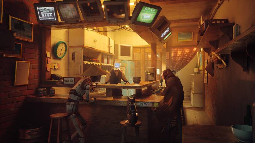 Stray lets you play as a cat. In this image the cat is sat in a bar next to some robots.