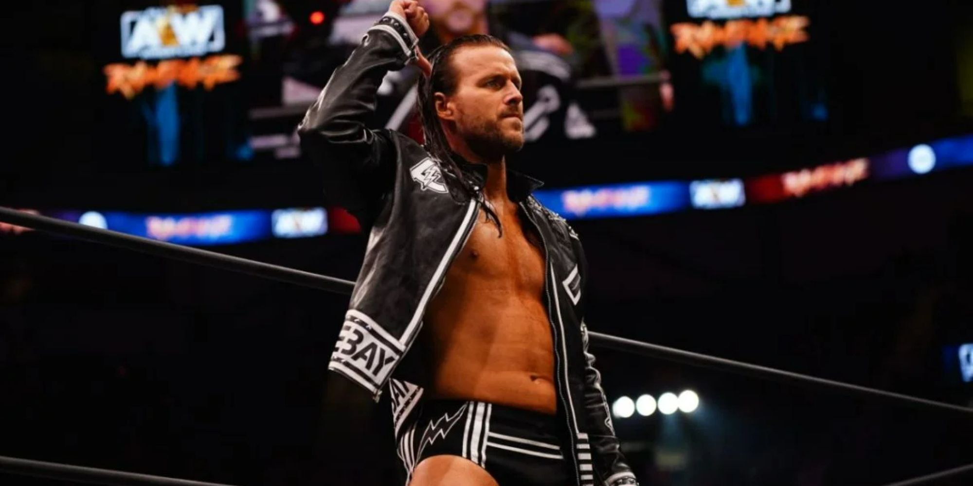 Former WWE and current AEW star Adam Cole standing on the ring apron pointing to himself