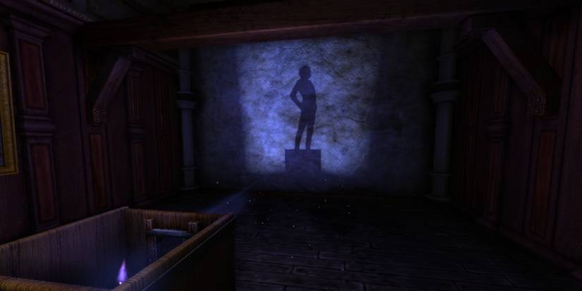 A dark room showing the outline of a statue on the far wall, cast in a blue light.