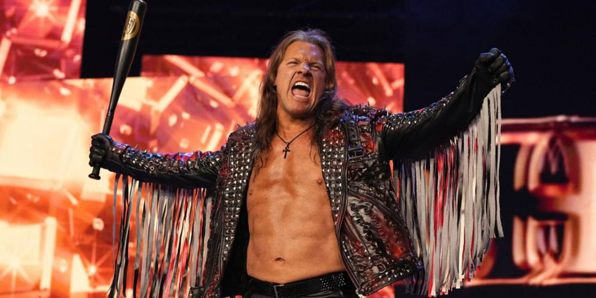 Former WWE and current AEW star Chris Jericho with his arms spread holding a baseball bat. He is wearing a jacket with tassles on the arms