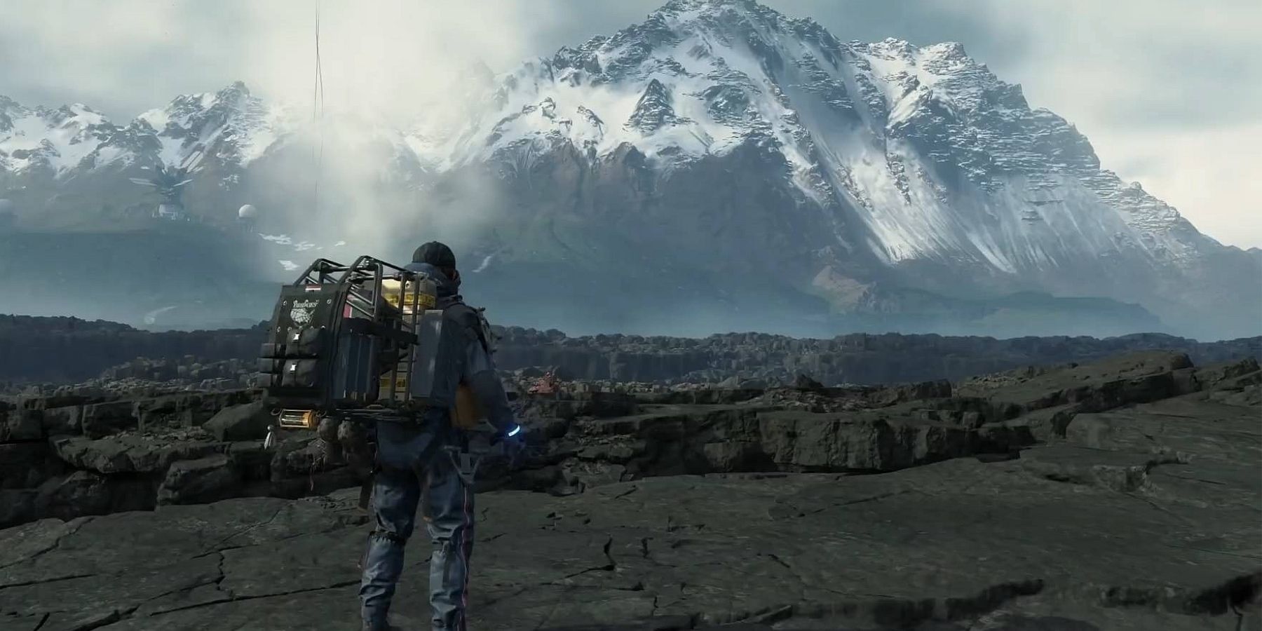 Sam looking at a mountain in the distance in Death Stranding
