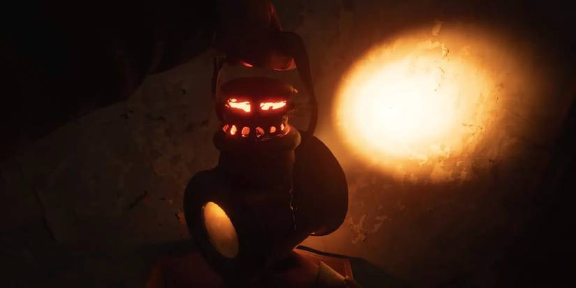 A lantern casting a harsh orange glow on the floor of a dark room. 