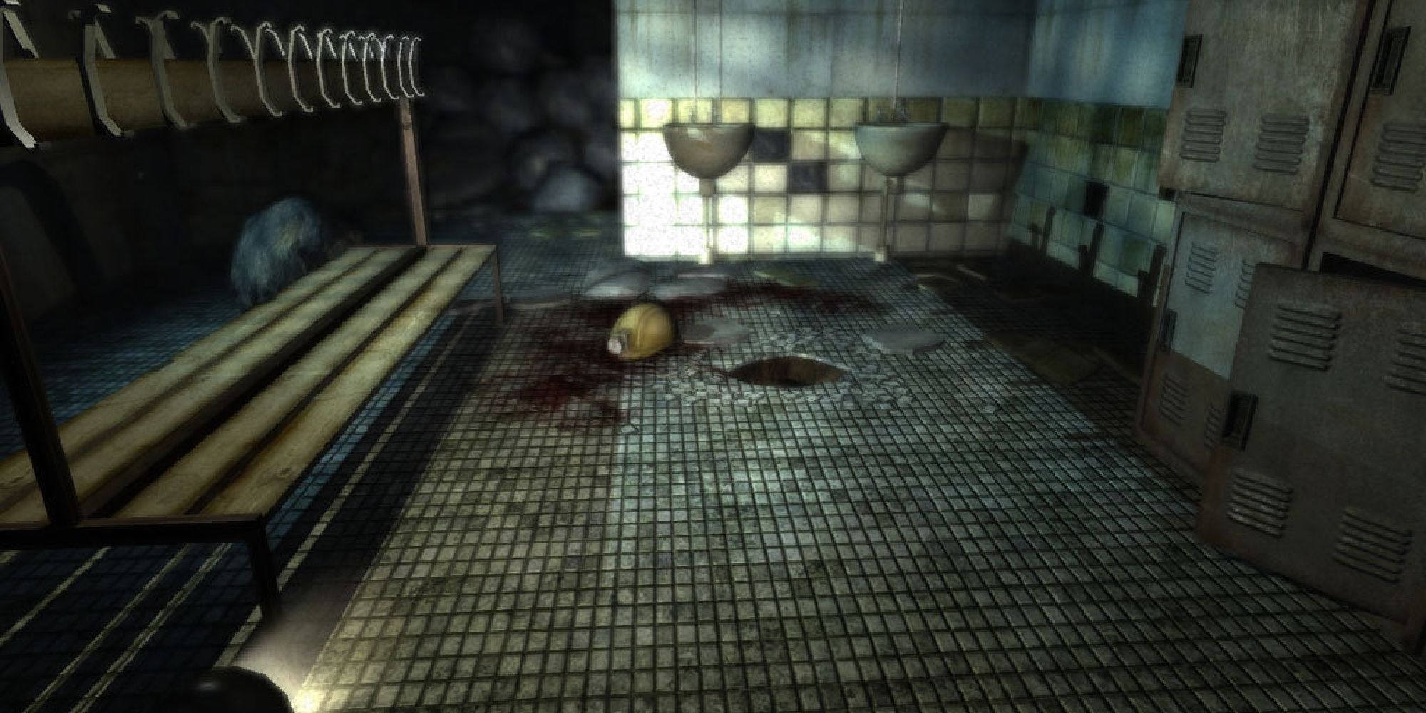 A screenshot of a dark locker room, the flashlight illuminating some blood on the floor. 