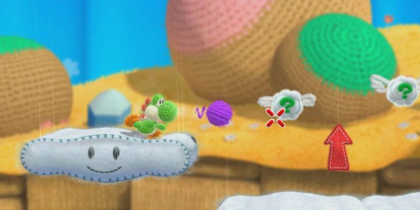 Yarn Yoshi tossing a ball of yarn off a platform