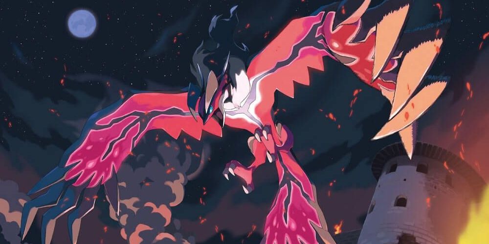 Yveltal surrounded by fire and collapsing buildings at night in Pokemon