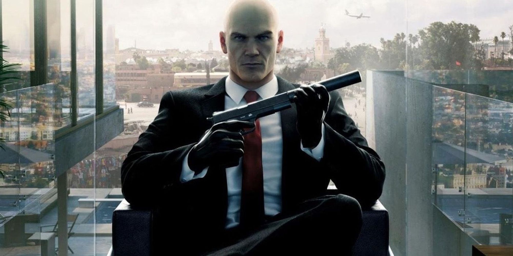 Agent 47 holding a silenced pistol against the backdrop of a cityscape
