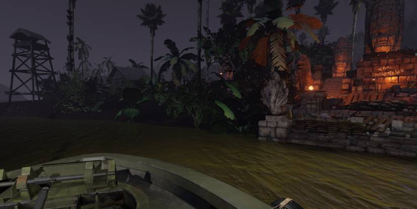 A military boat cruising down a dark river, ruins and jungle flora to the right.