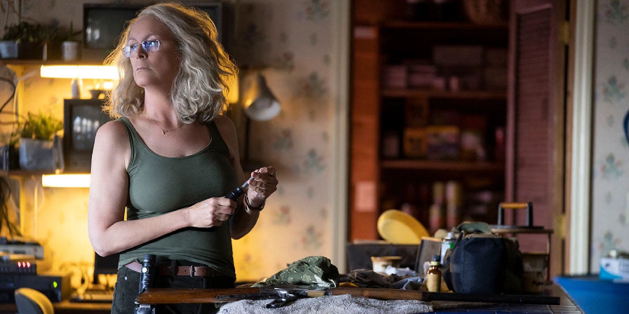 Jamie Lee Curtis starring as an older Laurie, holding a knife as she looks off to one side.