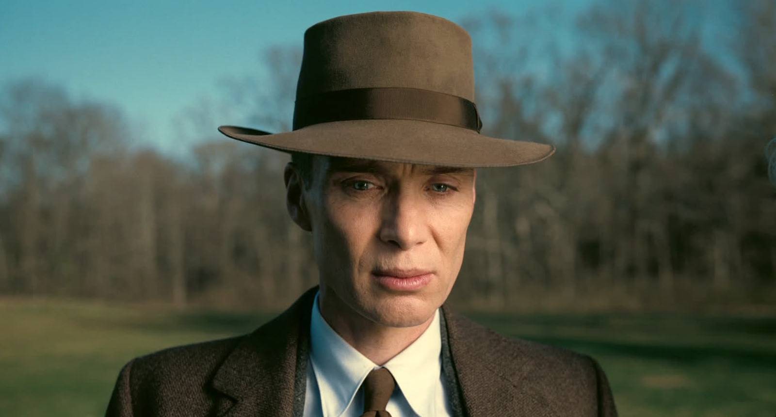 Oppenheimer looking troubled at a pond in Oppenheimer